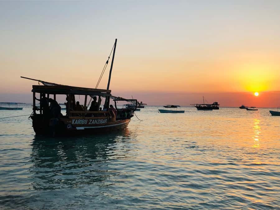 Zanzibar: Sunset Dhow Cruise With Pick Up - The onboard experience: fruit, refreshments, music, and dancing